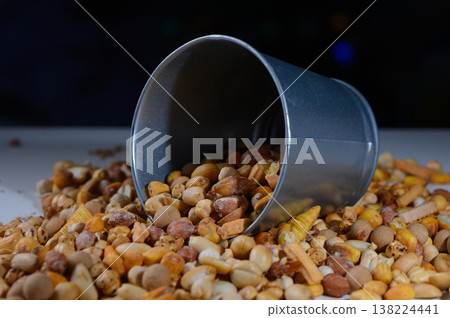 Colorful assortment of nuts and seeds spills from a tin container during a vibrant market day in autumn Colorful assortment of nuts and seeds spills from a tin container during a vibrant market day in autumn 138224441
