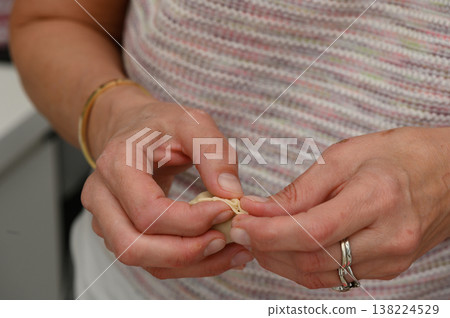 Skillful hands crafting intricate designs using delicate materials in a bright workshop 138224529