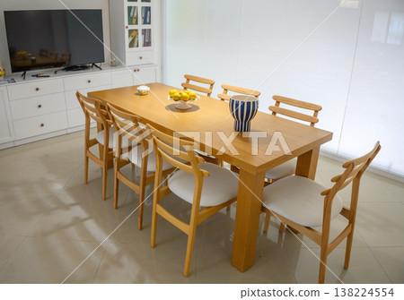 Elegant wooden dining table adorned with citrus centerpiece in a modern bright kitchen setting Elegant wooden dining table adorned with citrus centerpiece in a modern bright kitchen setting 138224554