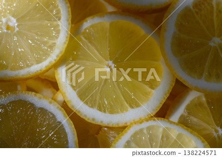 Freshly sliced lemons showcasing vibrant colors and textures in a sunny kitchen setting Freshly sliced lemons showcasing vibrant colors and textures in a sunny kitchen setting 138224571