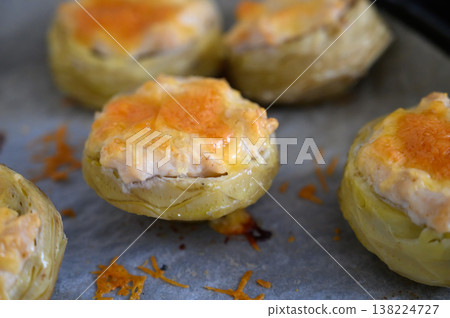 Savory artichoke hearts filled with creamy cheese and topped with golden brown crust during a sunny afternoon 138224727