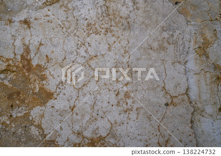 Texture of ancient weathered wall showcasing cracks and earthy colors in an abandoned setting Texture of ancient weathered wall showcasing cracks and earthy colors in an abandoned setting 138224732