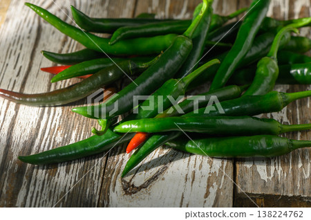 Fresh green chilies arranged artistically on a rustic wooden surface Fresh green chilies arranged artistically on a rustic wooden surface 138224762