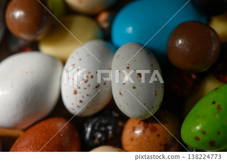 Colorful collection of decorative eggs nestled among vibrant candies during spring festivities Colorful collection of decorative eggs nestled among vibrant candies during spring festivities 138224773