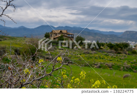 Rolling hills embrace an abandoned house under a brooding sky in rural landscape Rolling hills embrace an abandoned house under a brooding sky in rural landscape 138224775
