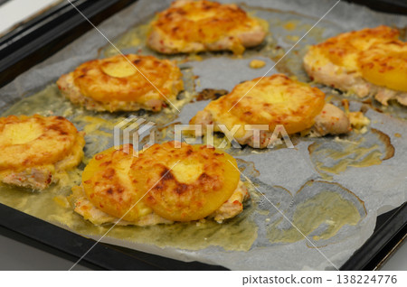 Delicious chicken topped with melted cheese and pineapple on a baking tray Delicious chicken topped with melted cheese and pineapple on a baking tray 138224776