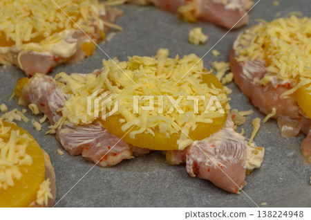 Juicy chicken topped with pineapple and cheese ready for baking in cozy kitchen Juicy chicken topped with pineapple and cheese ready for baking in cozy kitchen 138224948