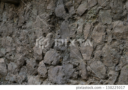 Unique texture of an ancient stone wall illuminated by soft natural light in a quiet setting Unique texture of an ancient stone wall illuminated by soft natural light in a quiet setting 138225017