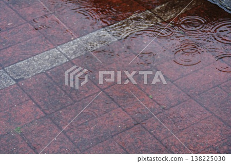 雨滴在人行道水窪中泛起的漣漪 雨滴在人行道水窪中泛起的漣漪 138225030
