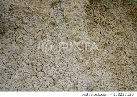 Cracked earth displays nature's artistry in a rural landscape during midday sun Cracked earth displays nature's artistry in a rural landscape during midday sun 138225126