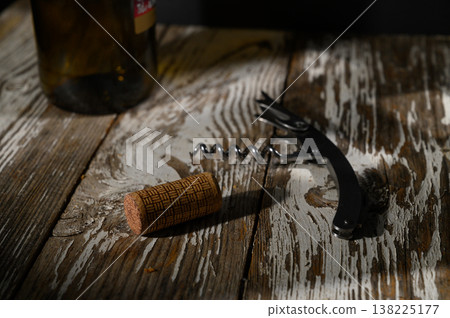 Enjoying an evening of fine wine with a corkscrew and bottle on a rustic wooden Enjoying an evening of fine wine with a corkscrew and bottle on a rustic wooden 138225177