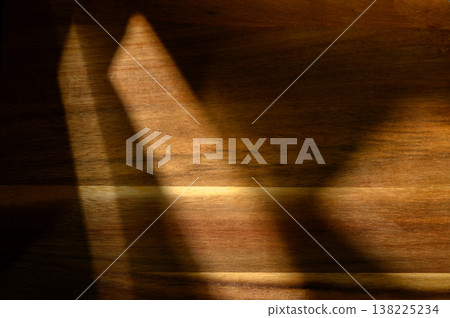 Shadows dance gracefully across a wooden surface during twilight hours, creating 138225234
