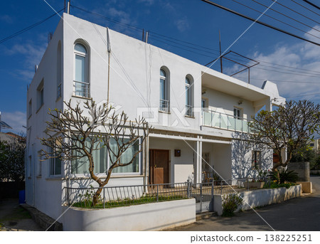 Charming white house with lush greenery in a peaceful coastal neighborhood 138225251
