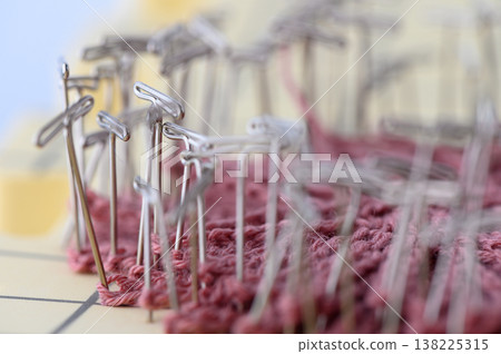 Knitted Fabric Blocked with T-Pins on White Background Knitted Fabric Blocked with T-Pins on White Background 138225315