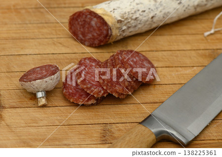 Delightful selection of sliced cured meat with a rustic knife on a wooden cutting board Delightful selection of sliced cured meat with a rustic knife on a wooden cutting board 138225361