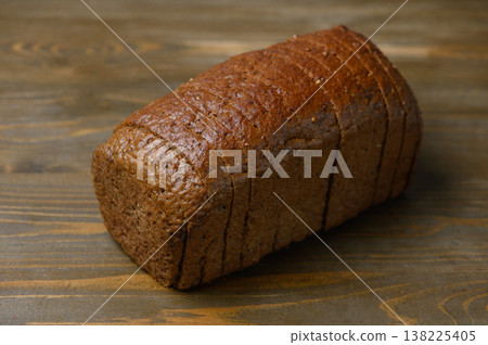 Sliced Loaf of Borodinsky Bread with Caraway Seeds on a Wooden Table. Rustic Still Life. Sliced Loaf of Borodinsky Bread with Caraway Seeds on a Wooden Table. Rustic Still Life. 138225405