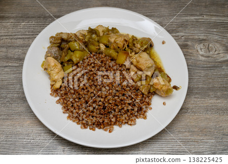 A traditional Eastern European dish served for lunch. An appetizing presentation in a deep bowl against the texture of a wooden table or countertop creates a cozy atmosphere. A traditional Eastern European dish served for lunch. An appetizing presentation in a deep bowl against the texture of a wooden table or countertop creates a cozy atmosphere. 138225425