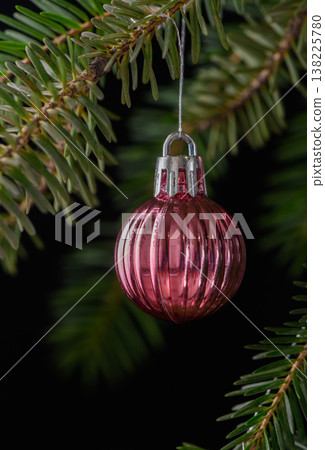 Pink Striped Christmas Ornament on Spruce Branch Pink Striped Christmas Ornament on Spruce Branch 138225780