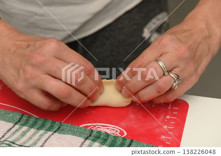 Creating delicate dumplings with skillful hands in a cozy kitchen during a rainy afternoon Creating delicate dumplings with skillful hands in a cozy kitchen during a rainy afternoon 138226048