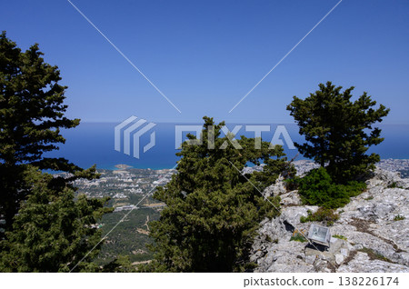 Panoramic view from hilltop near Saint Hilarion Castle, showing Kyrenia town, coastline, and distant sea under clear sky. Panoramic view from hilltop near Saint Hilarion Castle, showing Kyrenia town, coastline, and distant sea under clear sky. 138226174