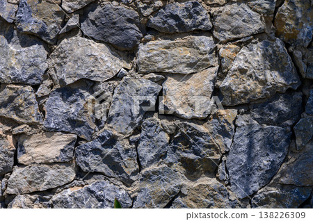 Authentic real stone wall texture, showcasing natural stone in an aged, rustic style. Ideal for architectural, construction, and design-themed projects. 138226309