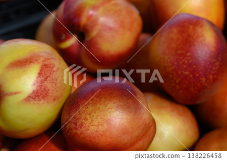 Vibrant display of freshly picked peaches showcasing their colorful skin in a sunlit market stall during summer Vibrant display of freshly picked peaches showcasing their colorful skin in a sunlit market stall during summer 138226458