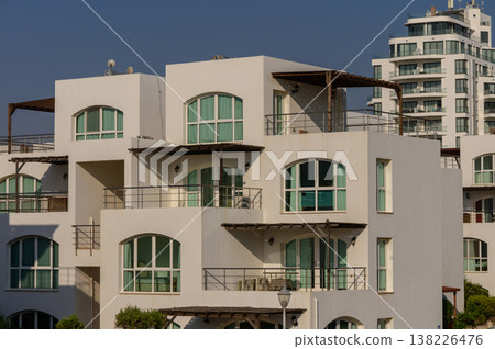 Elegant white villas in traditional Mediterranean style with red tile roofs, located on sunny Cyprus island. 138226476