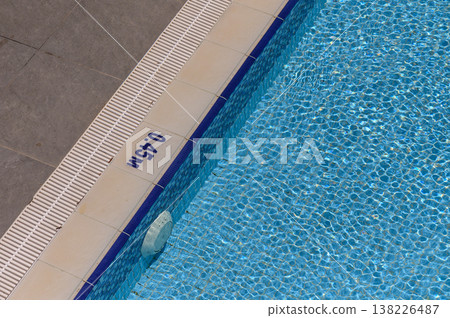 Edge of Swimming Pool with Depth Markings and Clear Water 138226487