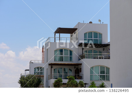 Stylish white villas surrounded by palm trees in a sunny Cypriot resort, reflecting Mediterranean charm and comfort. Stylish white villas surrounded by palm trees in a sunny Cypriot resort, reflecting Mediterranean charm and comfort. 138226495