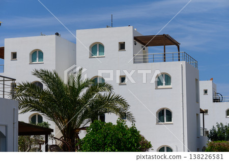 Elegant white villas overlooking the sea in Cyprus, designed in classic Mediterranean style with red tile roofs. Elegant white villas overlooking the sea in Cyprus, designed in classic Mediterranean style with red tile roofs. 138226581