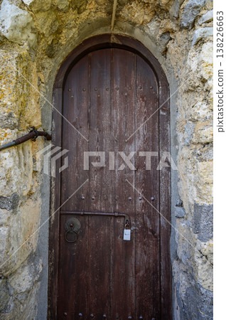 Weathered old wooden door set in the ancient stone walls of St. Hilarion Castle, Northern Cyprus, evoking medieval history and mystery. Weathered old wooden door set in the ancient stone walls of St. Hilarion Castle, Northern Cyprus, evoking medieval history and mystery. 138226663