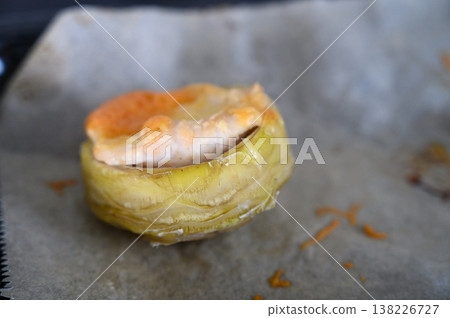 Delightful pastry filled with savory ingredients, resting on parchment paper in a warm kitchen Delightful pastry filled with savory ingredients, resting on parchment paper in a warm kitchen 138226727