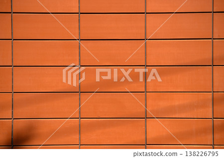 Warm hues of textured clay tiles on a modern building during afternoon sunlight Warm hues of textured clay tiles on a modern building during afternoon sunlight 138226795