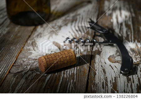 Cork and corkscrew resting on a rustic wooden surface after an evening of wine tasting 138226804