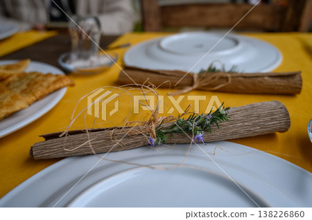 Elegant table setting featuring rustic decor with fresh herbs and handcrafted Elegant table setting featuring rustic decor with fresh herbs and handcrafted 138226860