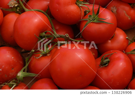Freshly harvested red tomatoes piled together at a local market showcasing nature's vibrant bounty during a sunny afternoon Freshly harvested red tomatoes piled together at a local market showcasing nature's vibrant bounty during a sunny afternoon 138226906