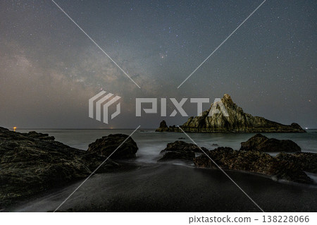 Waves crashing against the rocks and the Milky Way shining in the night sky 138228066
