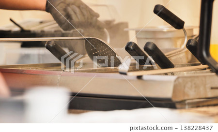 Chef hand cooking food in steam with slotted spoon 138228437