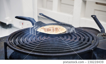 Cooking pancakes on a warm outdoor grill plate Cooking pancakes on a warm outdoor grill plate 138228439