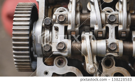 Car engine close up view showing gears, valves, springs, and cylinder head for repair Car engine close up view showing gears, valves, springs, and cylinder head for repair 138228583