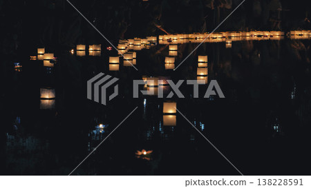 Paper river lanterns floating on dark water at night Paper river lanterns floating on dark water at night 138228591