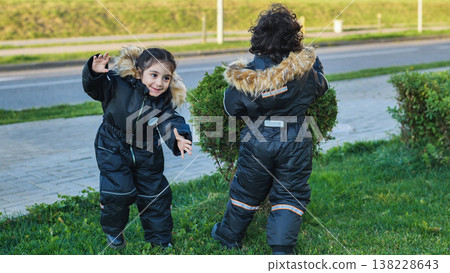 Children playing outdoors in winter snowsuits experiencing childhood joy Children playing outdoors in winter snowsuits experiencing childhood joy 138228643