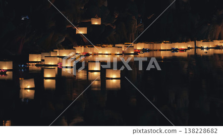 Glowing paper river lanterns floating on dark water Glowing paper river lanterns floating on dark water 138228682