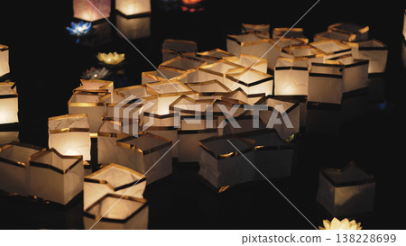 Floating paper river lanterns illuminating dark water 138228699
