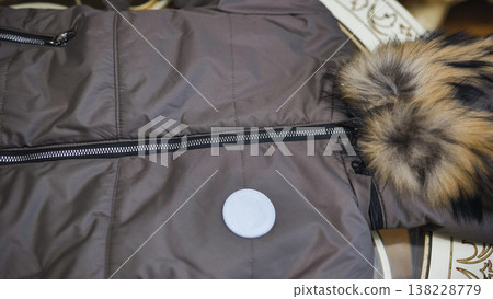 Brown winter jacket with fur collar, zippers, and white blank sticker for branding 138228779