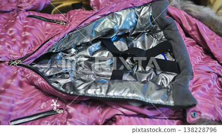 Pink winter overall showing thermal silver lining for insulation and warmth Pink winter overall showing thermal silver lining for insulation and warmth 138228796