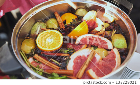 Large pot of warming fruit tea with citrus, kiwi, cinnamon, apple, and spices Large pot of warming fruit tea with citrus, kiwi, cinnamon, apple, and spices 138229021