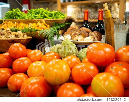 A restaurant's food display featuring fresh tomatoes and seasonal vegetables and mushrooms. A restaurant's food display featuring fresh tomatoes and seasonal vegetables and mushrooms. 138229242