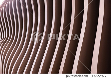 Modern wavy architectural facade showing parallel lines and rhythmic brown design Modern wavy architectural facade showing parallel lines and rhythmic brown design 138229270