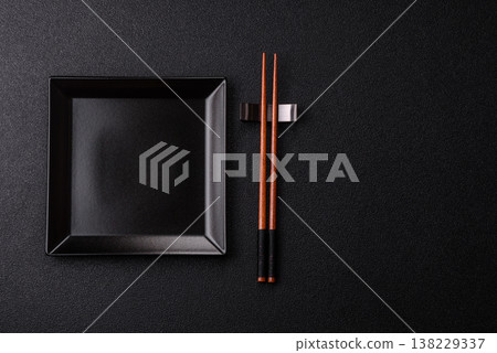 An empty ceramic square black plate with chopsticks for Asian food. An empty square plate An empty ceramic square black plate with chopsticks for Asian food. An empty square plate 138229337